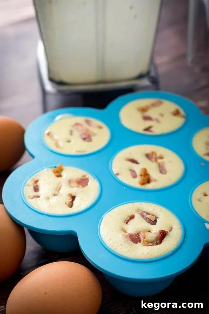 Fluffy Instant Pot Breakfast Bites 3 Uncooked egg mixture in a blue silicone mold, ready to be cooked in an Instant Pot, showing the various fillings before pressure cooking.