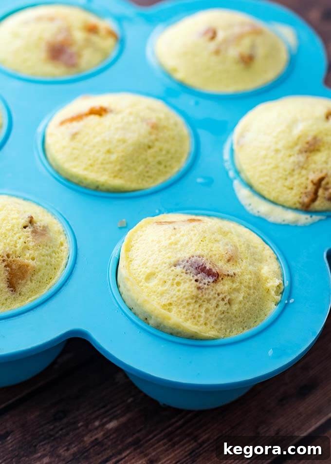 Fluffy Instant Pot Breakfast Bites 4 Perfectly cooked Instant Pot Egg Bites cooling in a blue silicone mold, slightly puffed up and golden.