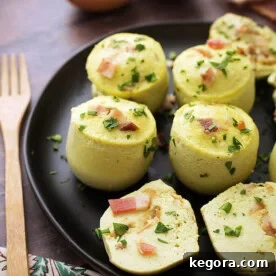 Several Instant Pot Egg Bites on a black plate next to a wooden fork, highlighting the delicious result.