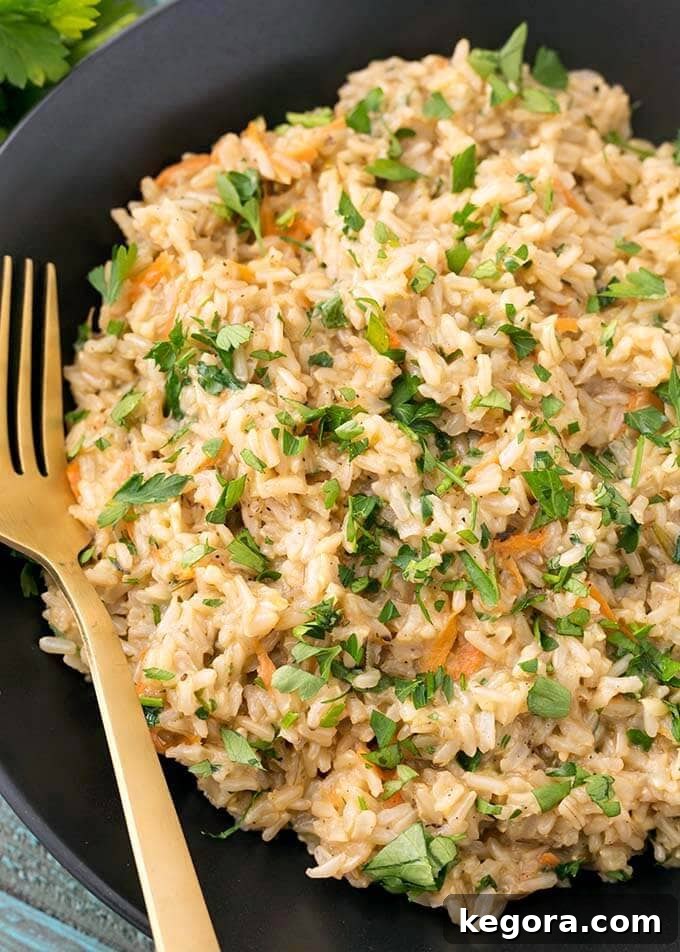 Closeup of Brown Rice Pilaf in a black bowl with gold fork