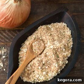 Homemade Onion Soup Mix in a dark wooden leaf-shaped bowl with a wooden spoon