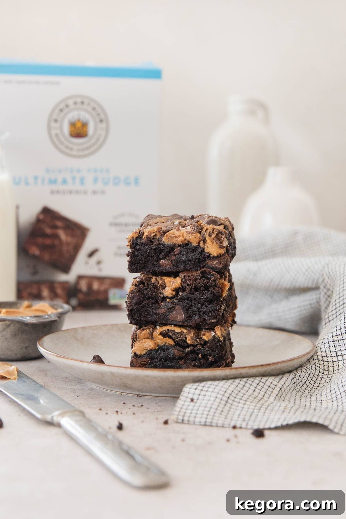 Perfectly sliced gluten-free peanut butter brownies, stacked on a plate, showcasing their fudgy texture and swirl.