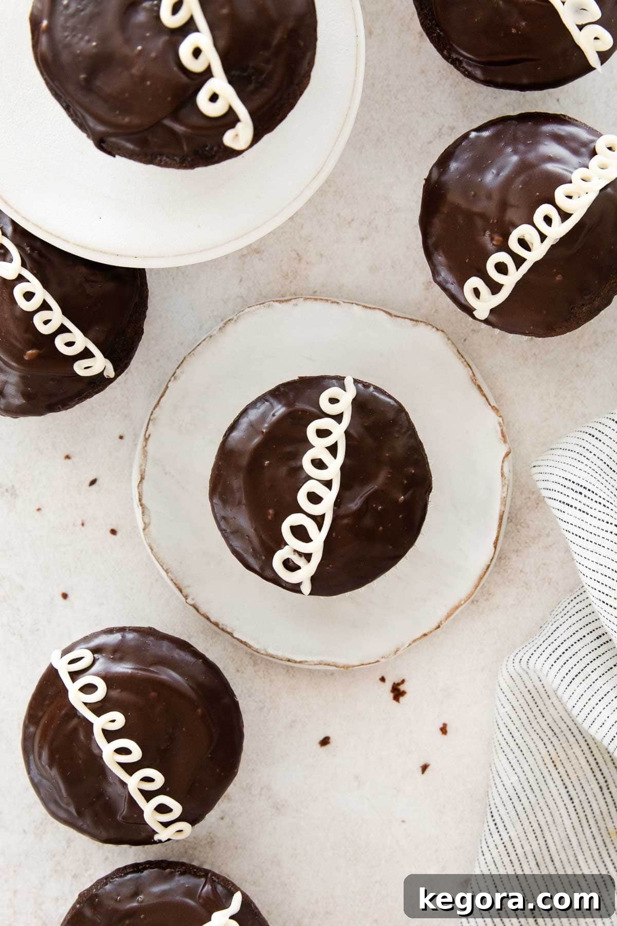 A perfectly glazed and swirled gluten-free Hostess cupcake on a kitchen counter, showcasing its classic appearance.