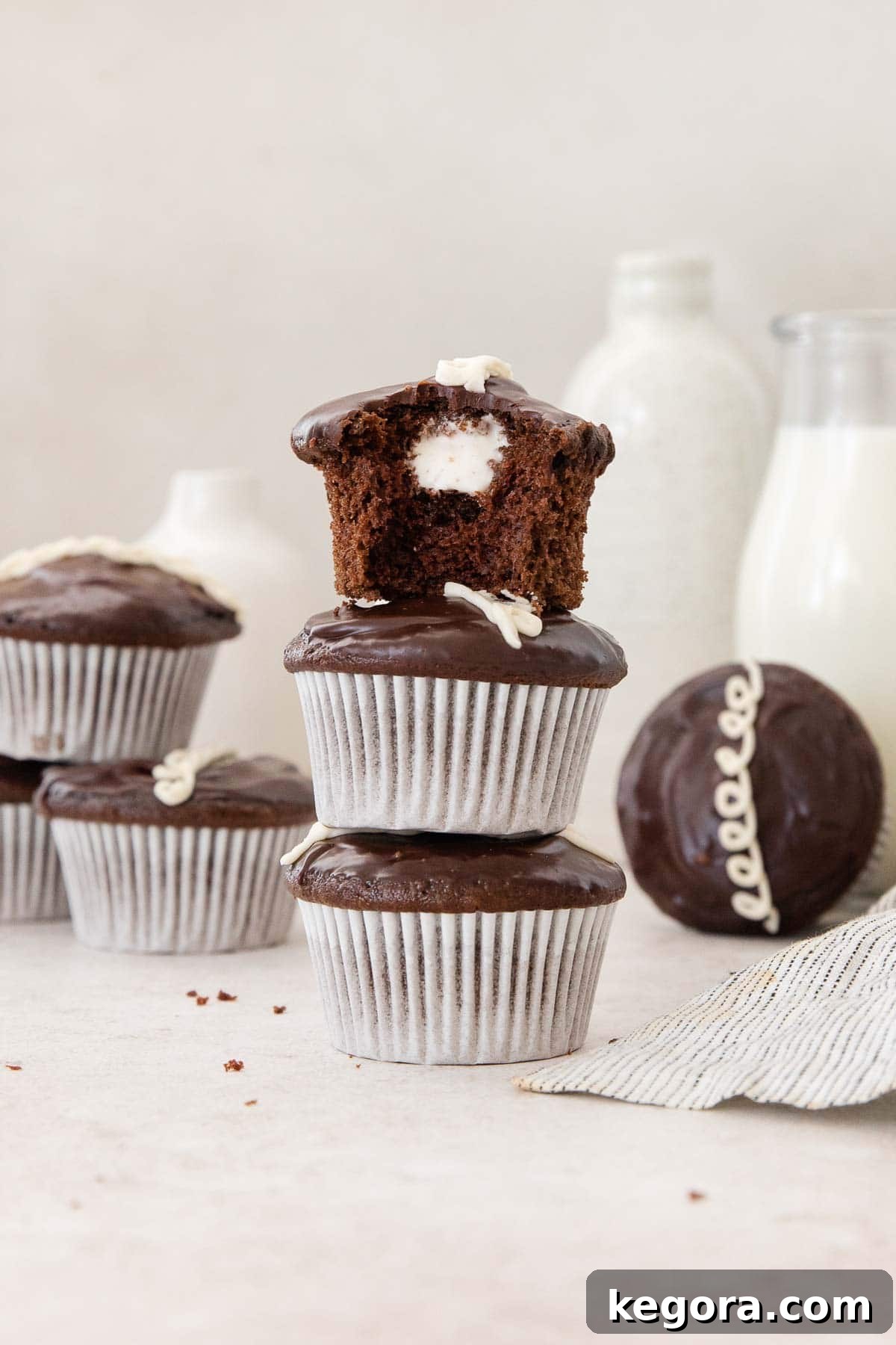 A stack of three perfectly prepared gluten-free Hostess cupcakes, showcasing their intricate layers and classic design.