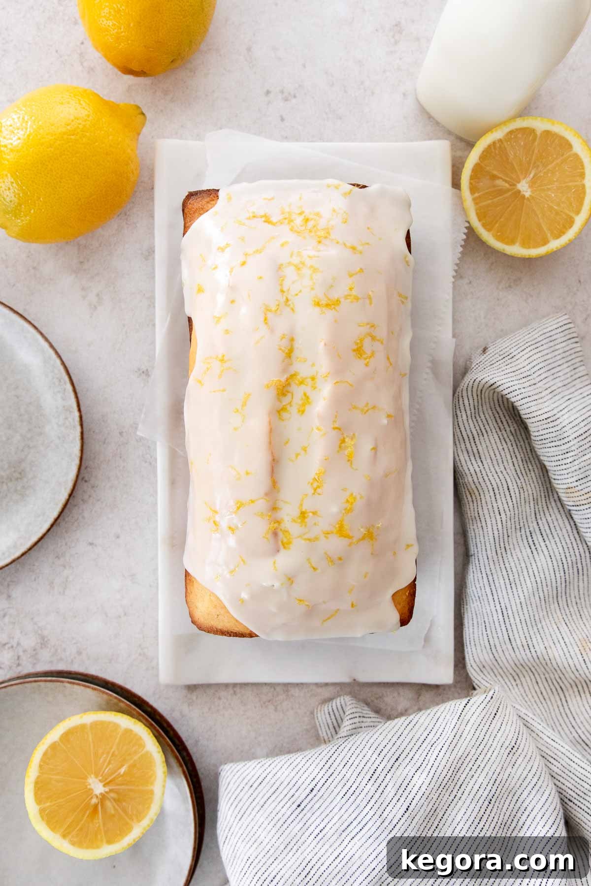 A beautifully glazed gluten-free lemon loaf on a countertop, ready to be sliced.