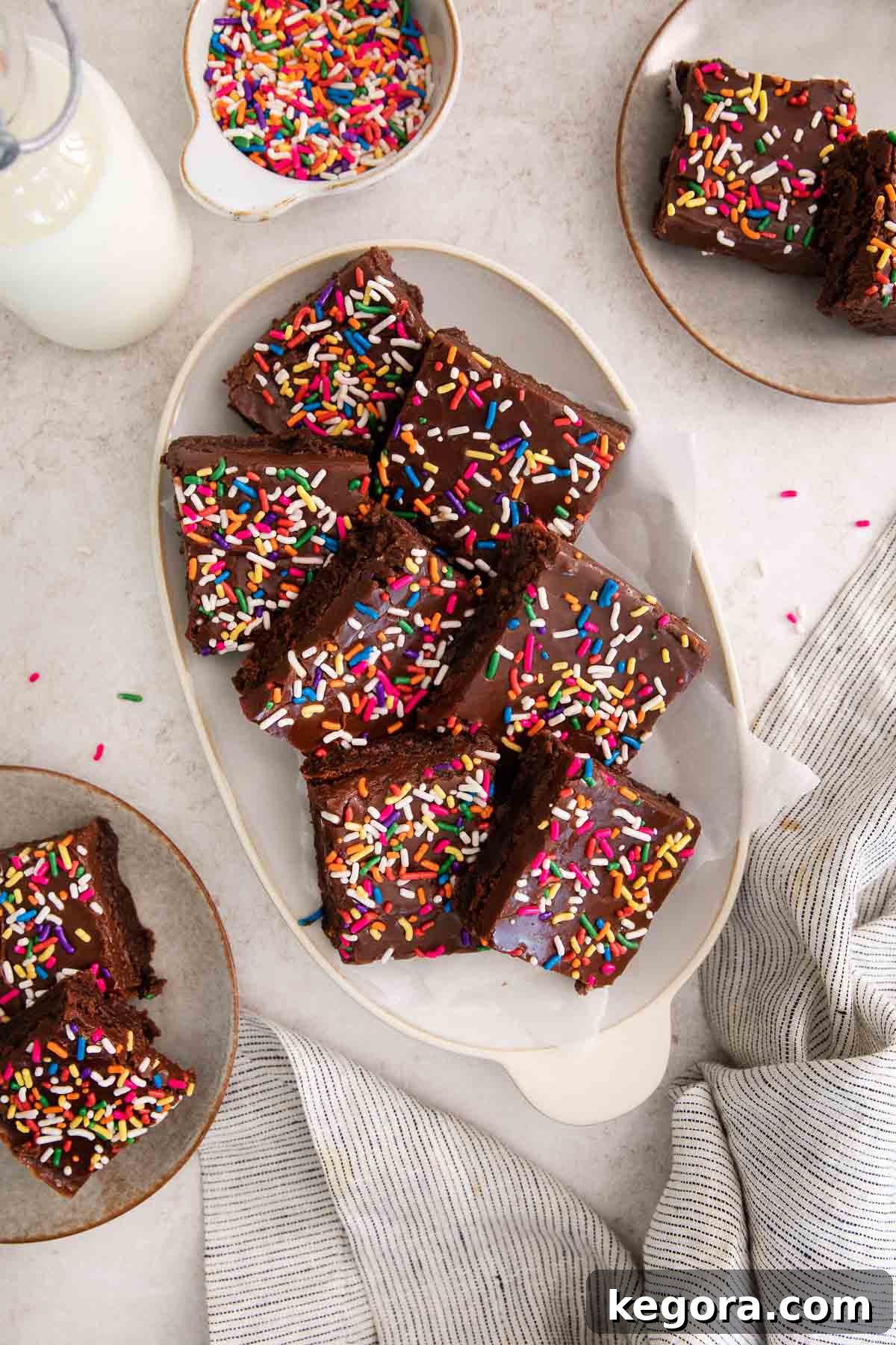 Delicious Gluten-Free Brownies for Birthday Celebrations 3 Sliced brownies topped with fudge frosting and rainbow sprinkles on a platter.