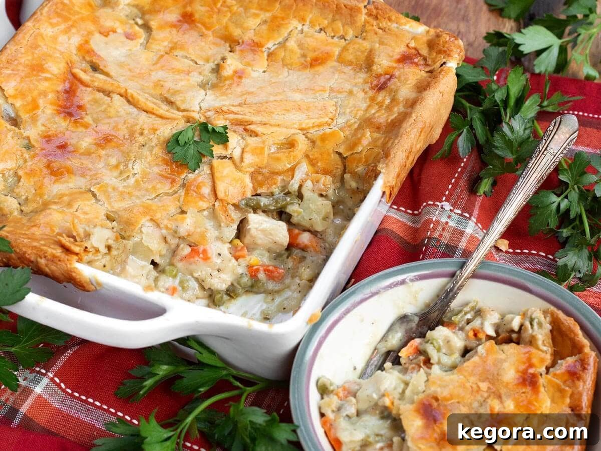 Classic Chicken Pot Pie with Flaky Butter Crust 2 chicken pot pie in white baking dish with a serving in a small dish