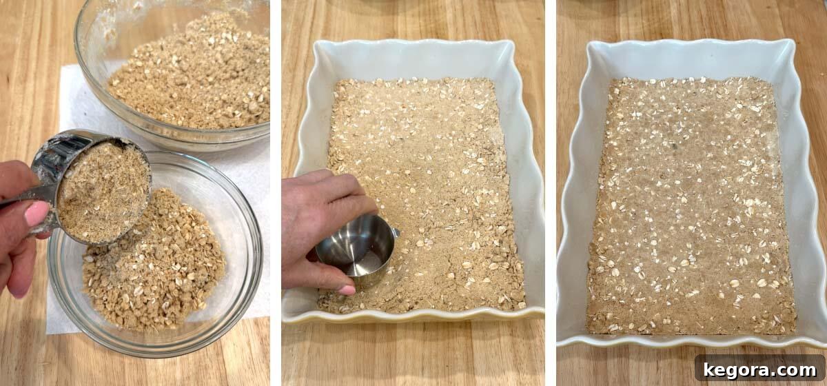 Salted Caramel Apple Crumble Bars 6 Oat crust being pressed into a 13x9-inch baking dish